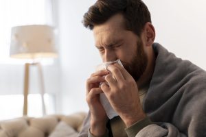 homme qui éternue à cause d´une infection